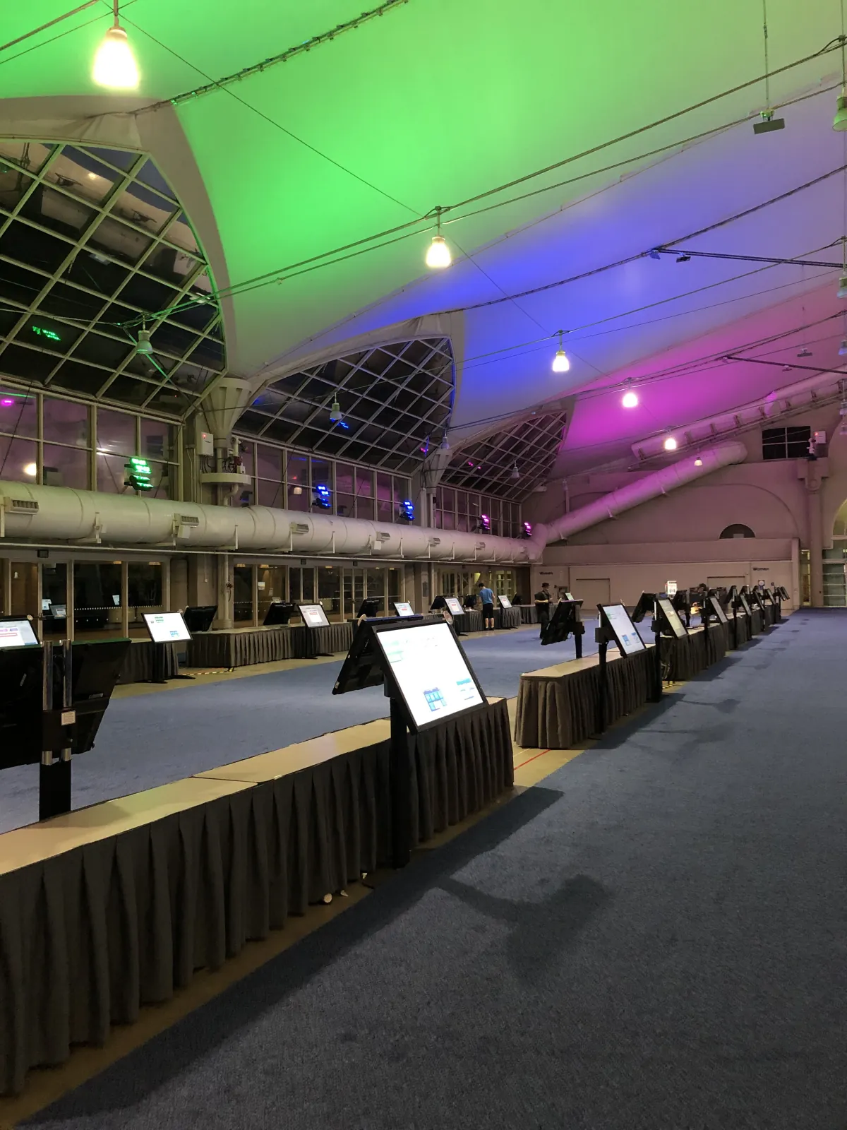 Touchscreen kiosks on stands along draped tables in a hall at the San Diego Convention Center