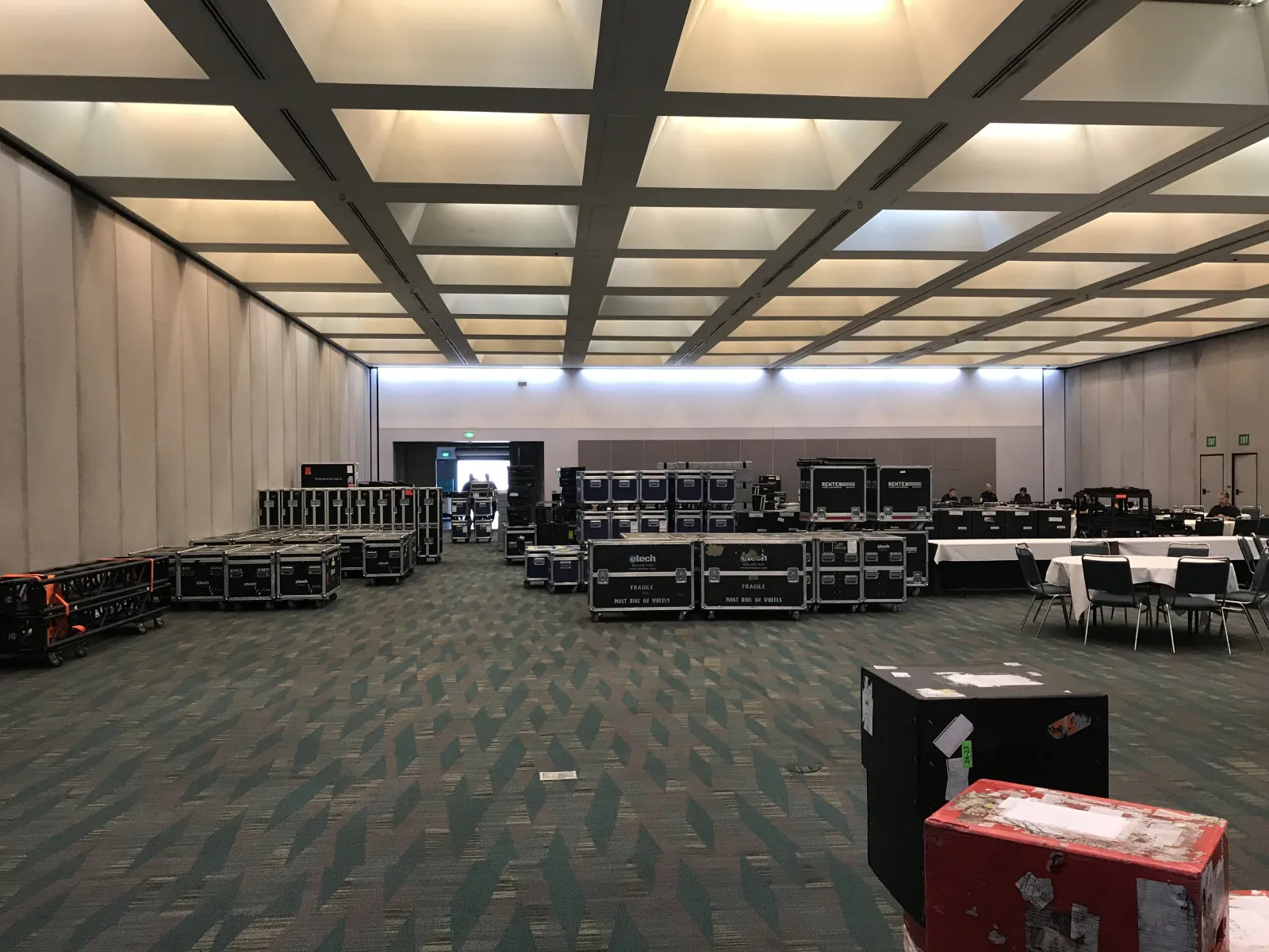Road cases staged on the floor of an empty convention hall before setup