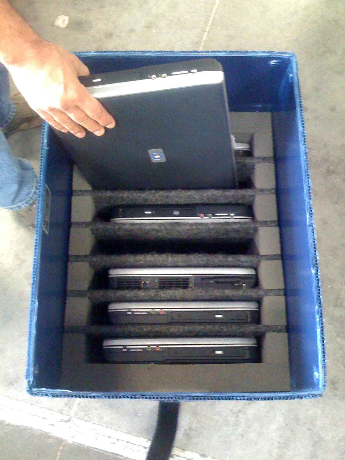 Laptops packed upright in a padded crate, ready to ship