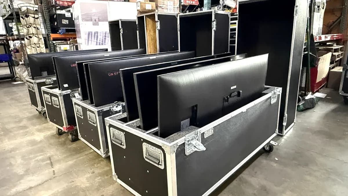 Large screens packed upright into padded road cases on castors, ready to ship